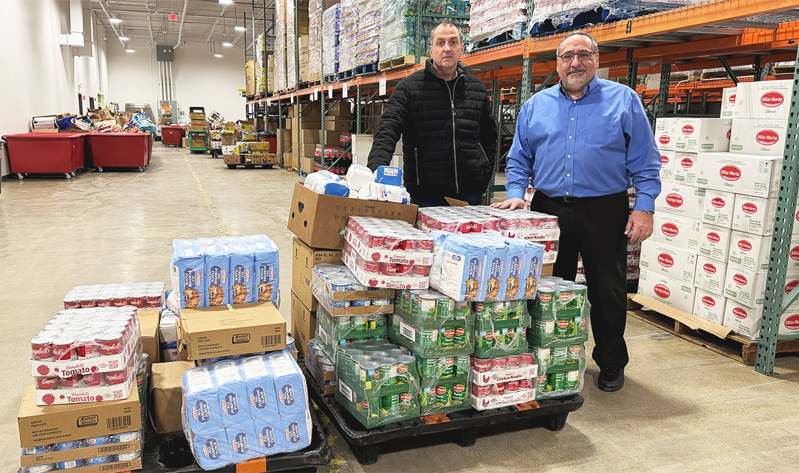 BrightBridge Facilities Manager Robert Pope (left) and Anthony Marino dropping off donated food to the Merrimack Valley Food Bank in Lowell, Mass.