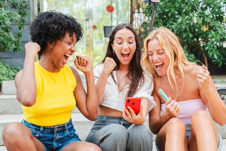 Image of three women looking at a phone